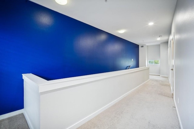 hallway featuring light colored carpet