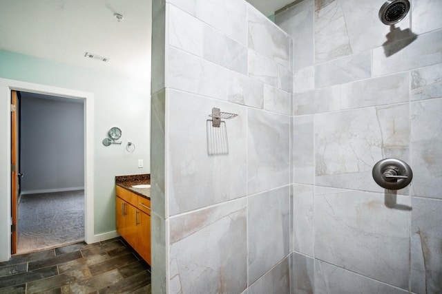 503 Swanee Dr Unit 19, Austin, TX 78752 - bathroom featuring vanity, tiled shower, and wood finished floors