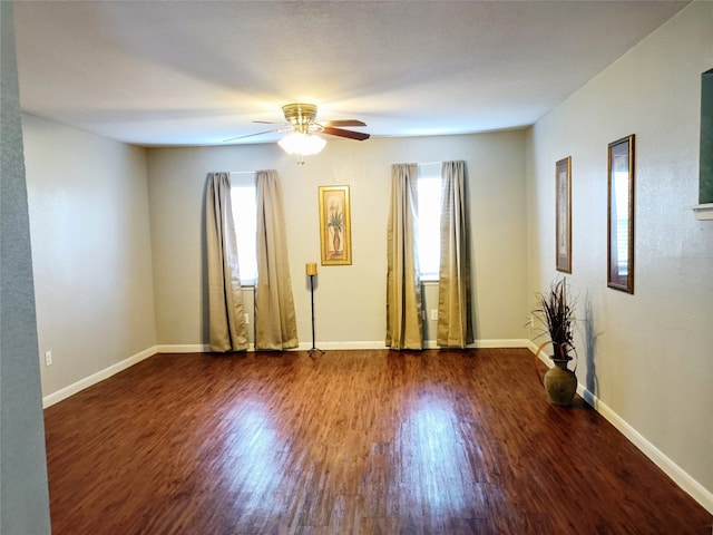 empty room with dark wood-type flooring and ceiling fan