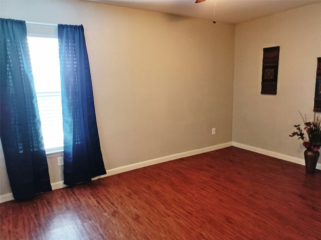 spare room with a wealth of natural light, dark hardwood / wood-style floors, and ceiling fan