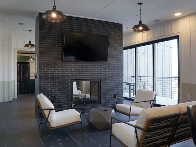 living room with dark tile patterned floors and a tile fireplace