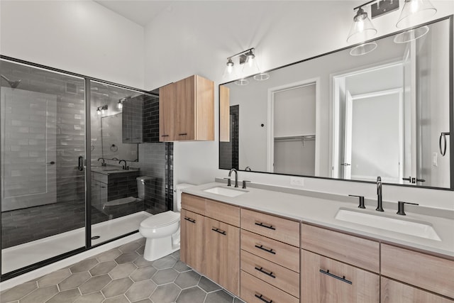 bathroom featuring tile patterned flooring, vanity, an enclosed shower, and toilet