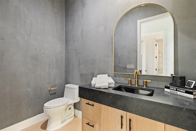 bathroom with hardwood / wood-style flooring, vanity, and toilet