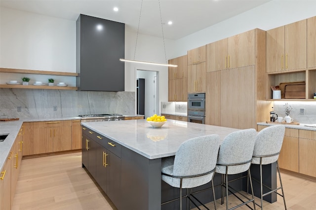 kitchen featuring a breakfast bar, a kitchen island, and light hardwood / wood-style flooring