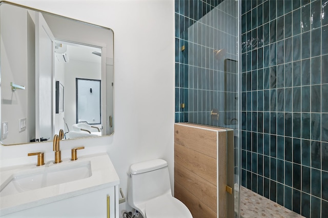 bathroom featuring vanity, toilet, and tiled shower