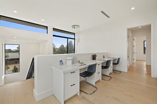 office with a healthy amount of sunlight and light wood-type flooring