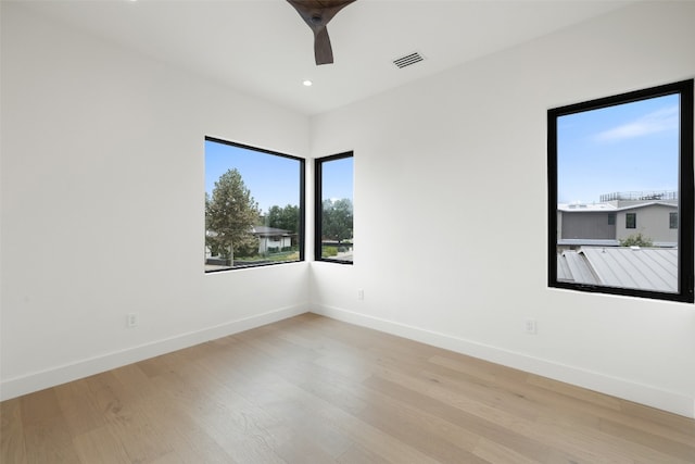 empty room with ceiling fan and light hardwood / wood-style floors