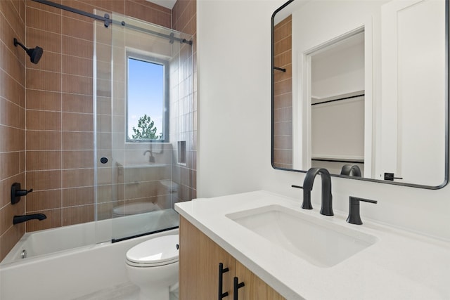 full bathroom featuring shower / bath combination with glass door, vanity, and toilet