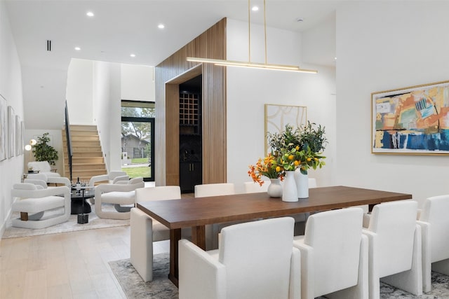 dining area featuring a high ceiling and light hardwood / wood-style flooring