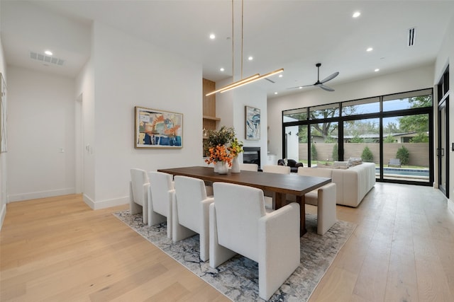 dining space with ceiling fan and light wood-type flooring