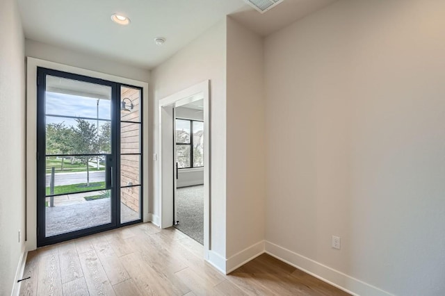 9103 Cattle Baron Path, Austin, TX 78747 - doorway with light wood finished floors, baseboards, and recessed lighting
