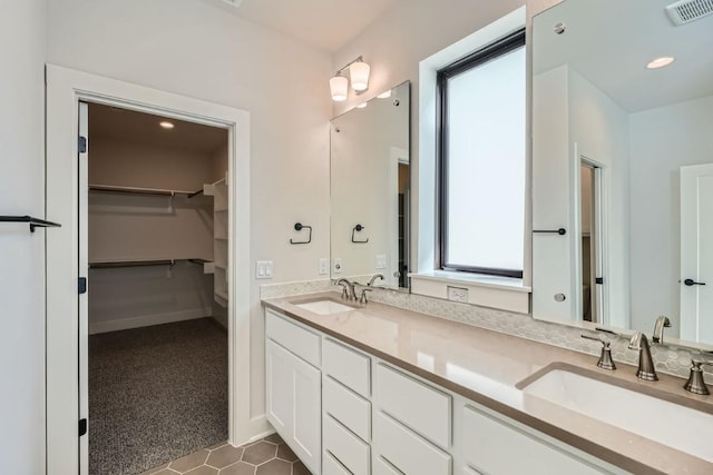 9103 Cattle Baron Path, Austin, TX 78747 - bathroom featuring double vanity, a spacious closet, and tile patterned floors