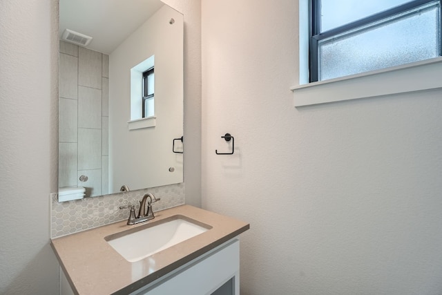 bathroom with vanity and tasteful backsplash