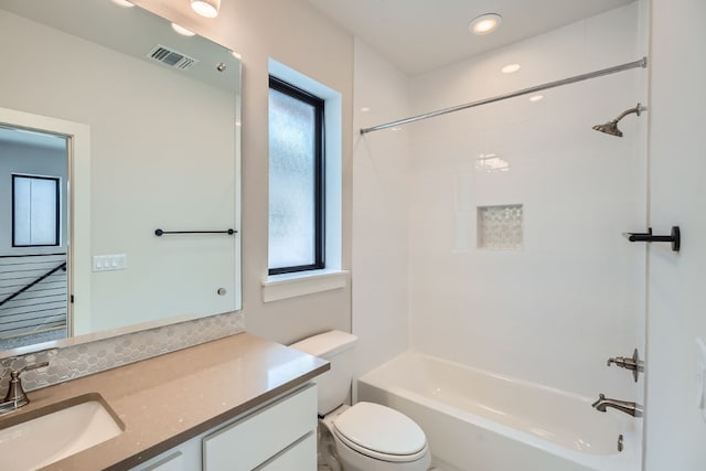 full bathroom with a wealth of natural light, vanity, toilet, and tiled shower / bath