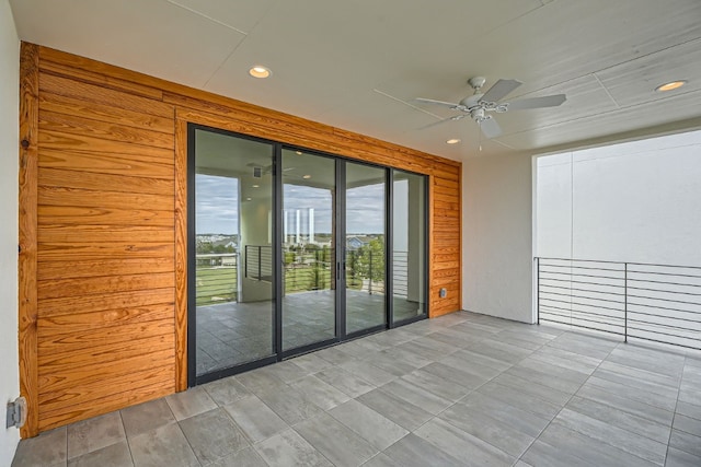 spare room featuring wood walls and ceiling fan