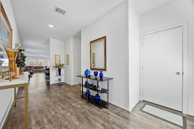foyer with wood finished floors and recessed lighting