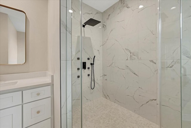 full bathroom with a marble finish shower and vanity