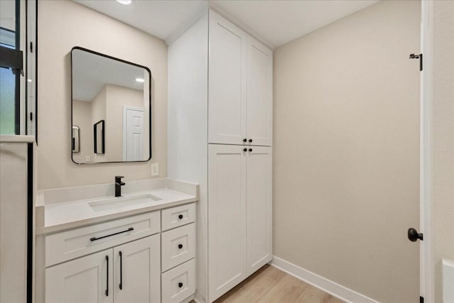 bathroom with baseboards, wood finished floors, and vanity