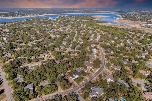 aerial view at dusk featuring a water view