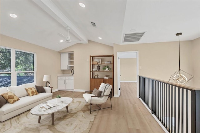 sitting room with lofted ceiling with beams, ceiling fan, visible vents, baseboards, and light wood finished floors