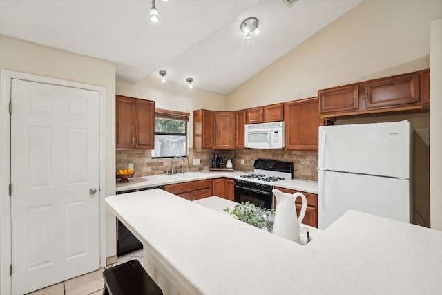 kitchen featuring sink, light tile patterned floors, white appliances, a breakfast bar area, and lofted ceiling