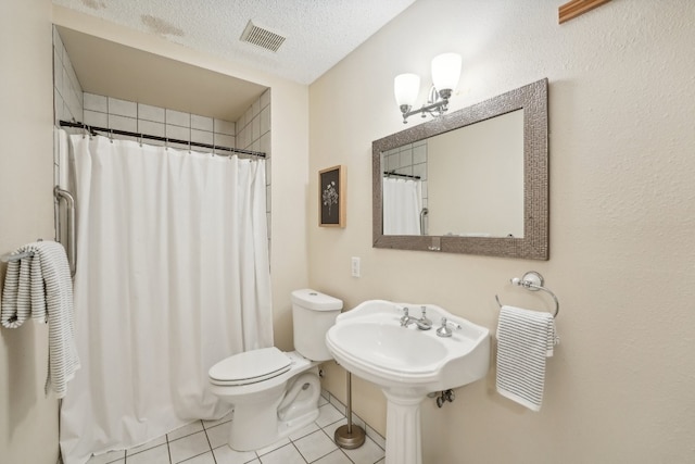 bathroom featuring curtained shower, a textured ceiling, toilet, and tile patterned flooring