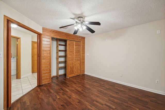 unfurnished bedroom featuring a textured ceiling, a closet, ceiling fan, and dark hardwood / wood-style flooring