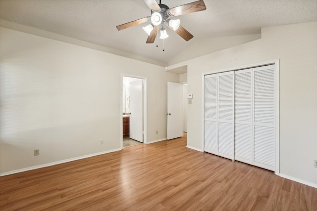 unfurnished bedroom with light hardwood / wood-style floors, vaulted ceiling, ensuite bath, a closet, and ceiling fan