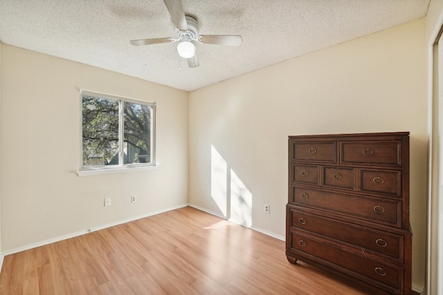 interior space with ceiling fan, light hardwood / wood-style flooring, and a textured ceiling