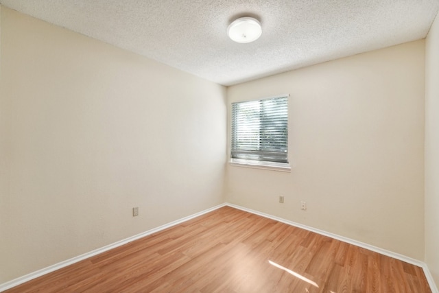 empty room featuring hardwood / wood-style flooring and a textured ceiling