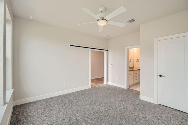 9031 Cattle Baron Path, Austin, TX 78747 - unfurnished bedroom featuring light carpet, baseboards, ensuite bathroom, and a ceiling fan