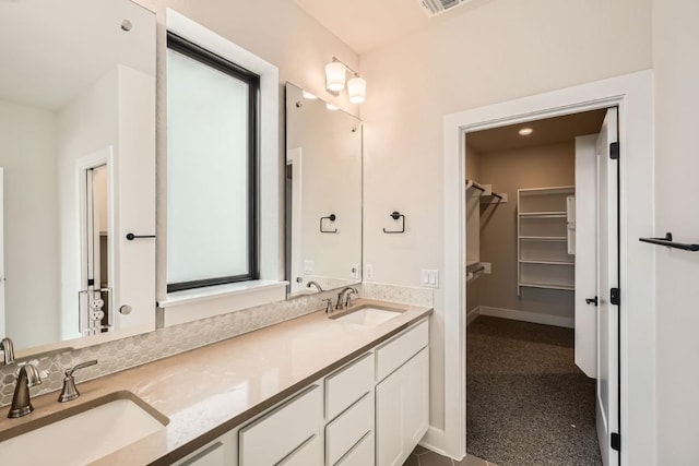9031 Cattle Baron Path, Austin, TX 78747 - full bathroom with a walk in closet, double vanity, and baseboards