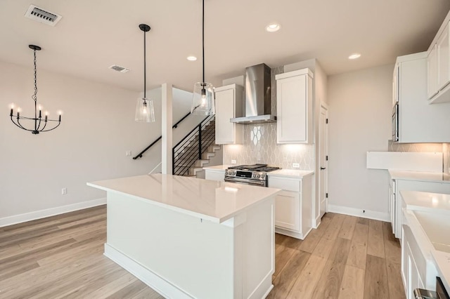 9031 Cattle Baron Path, Austin, TX 78747 - kitchen with wall chimney exhaust hood, stainless steel appliances, light wood finished floors, baseboards, and a center island