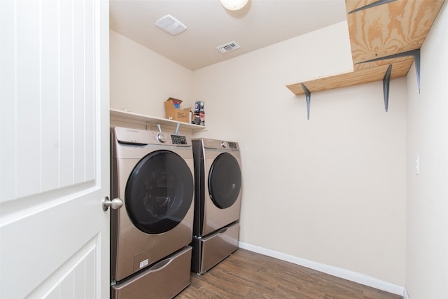 laundry area with dark wood-type flooring and washing machine and clothes dryer