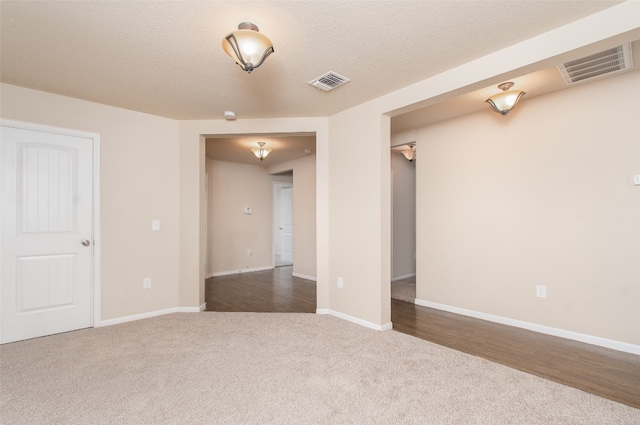 spare room featuring hardwood / wood-style floors and a textured ceiling