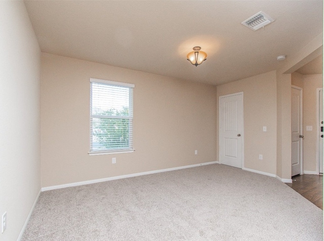 unfurnished room with dark carpet