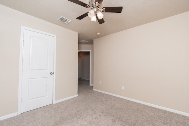 unfurnished bedroom with light carpet, a textured ceiling, and ceiling fan