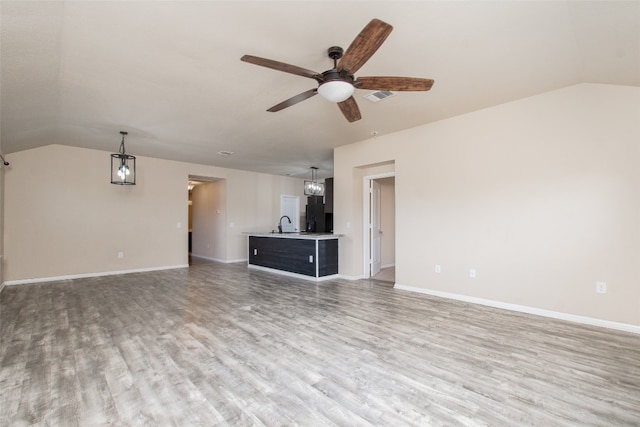 unfurnished living room featuring ceiling fan, vaulted ceiling, and light hardwood / wood-style flooring