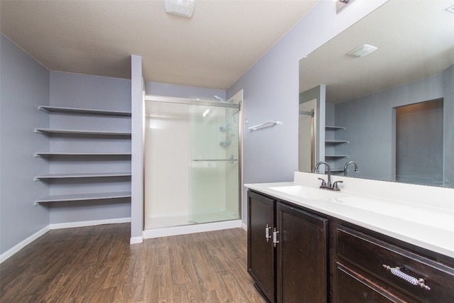 bathroom with a shower with door, vanity, and wood-type flooring