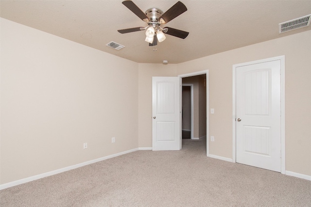 carpeted spare room featuring ceiling fan and a textured ceiling