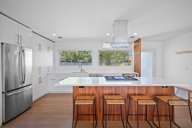 kitchen with sink, white cabinetry, a breakfast bar area, and stainless steel appliances