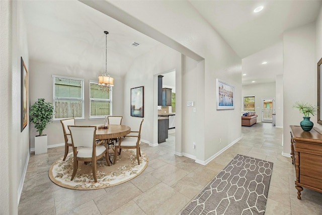 dining room with vaulted ceiling and a notable chandelier