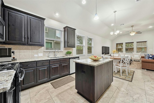 kitchen with hanging light fixtures, plenty of natural light, a kitchen island, and lofted ceiling