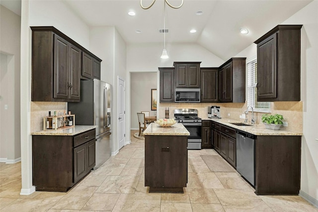 kitchen with tasteful backsplash, stainless steel appliances, hanging light fixtures, sink, and a center island