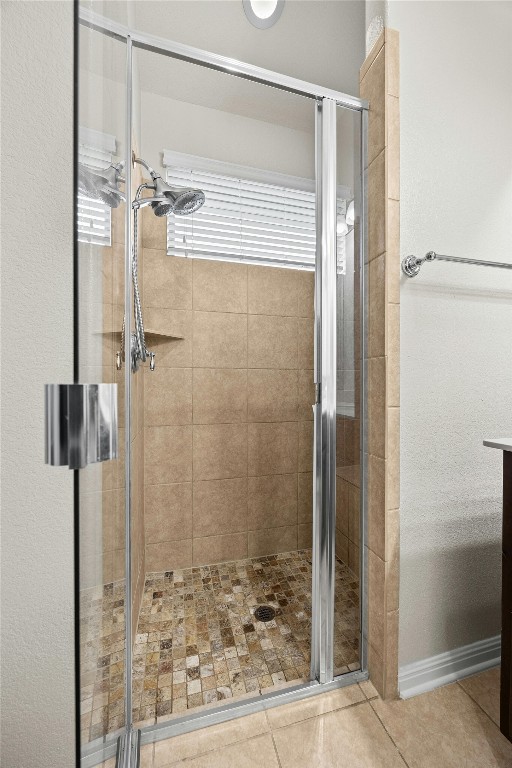 bathroom with tile patterned floors and a shower with shower door