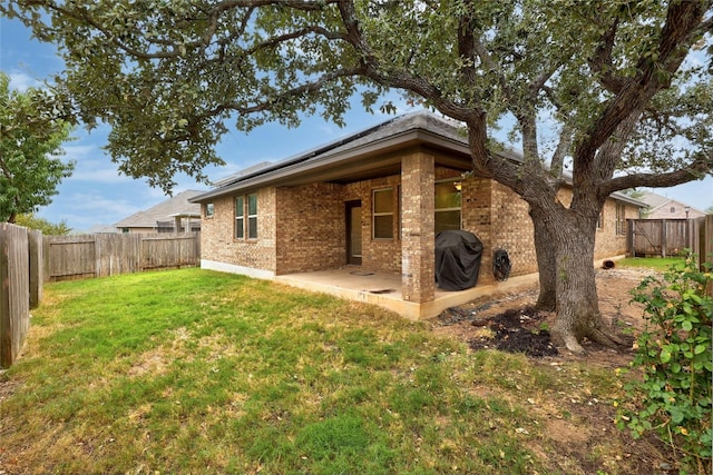 rear view of property with a patio and a lawn