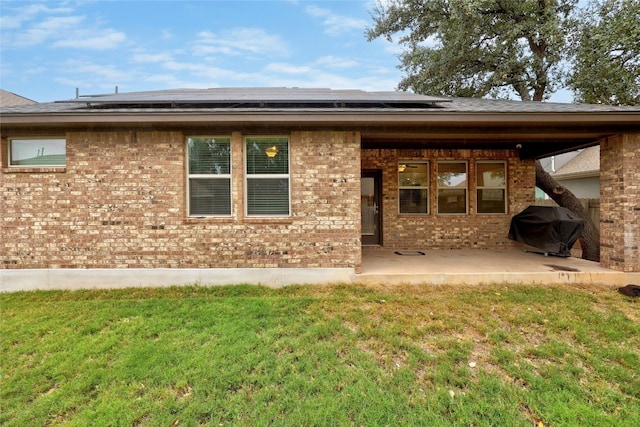 back of property featuring a patio area and a lawn