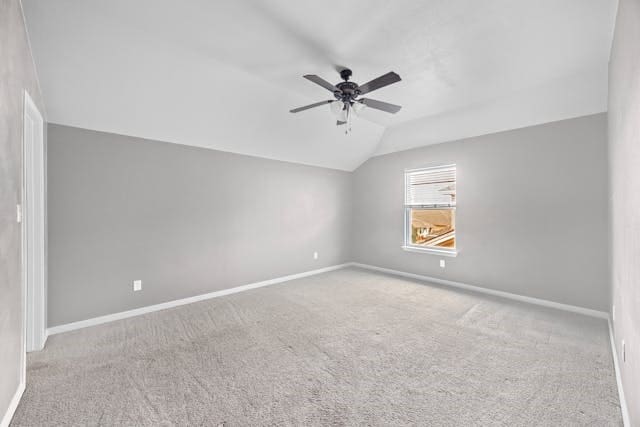 carpeted empty room featuring vaulted ceiling and ceiling fan