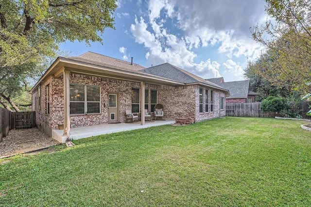 back of house with a yard and a patio