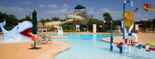 view of swimming pool with a water slide and a patio